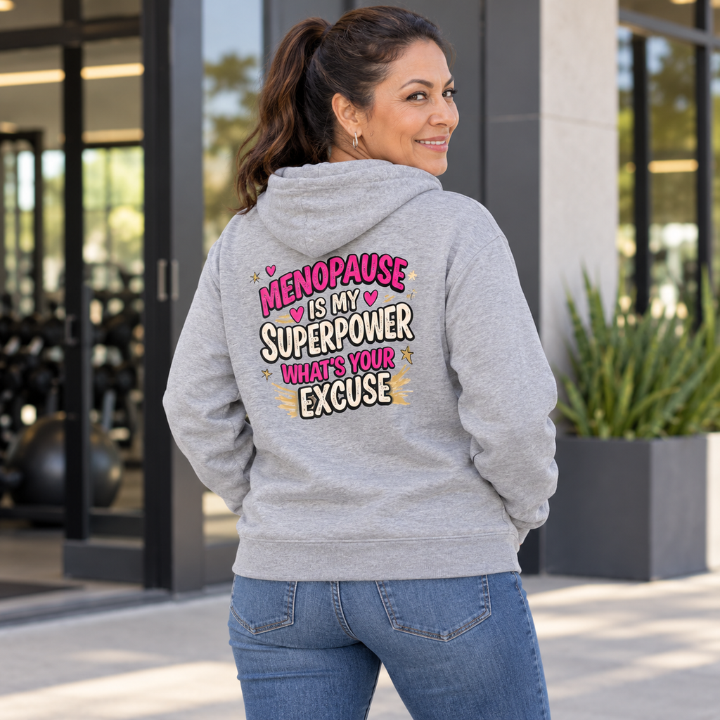 Latina woman in her 50s wearing the Menopause Is My Superpower grey hoodie, back view